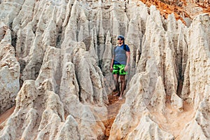 Man tourist stands in the sandy rocks of the Fairy Steam in the Red Canyon in Vietnam