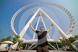 The man tourist threw up her hands in delight at the sight Ain Eye DUBAI - One of the largest Ferris Wheels in the World,