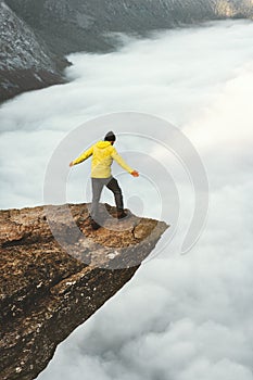 Man tourist on Trolltunga rocky cliff edge mountains