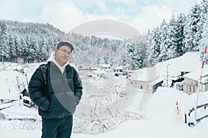 man tourist Visiting Ginzan Onsen in Yamagata, happy Traveler sightseeing Japanese Onsen village with Snow in winter season.