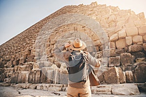 Man tourist walks background of pyramids in Giza Cairo Egypt, sun light