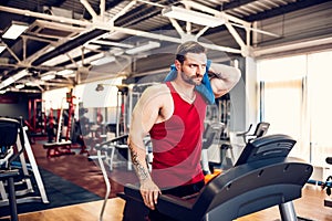 Man with a towel beside a treadmill