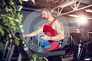 Man with a towel beside a treadmill