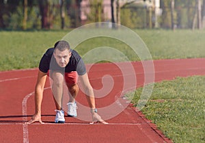 Man on track starting to run. Healthy fitness concept with active lifestyle.