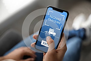 Man tracking parcel via smartphone indoors, closeup