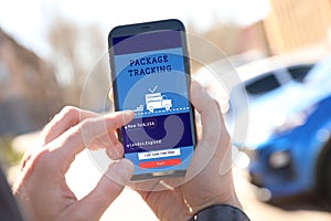 Man tracking parcel via smartphone outdoors, closeup