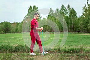 A man in a tracksuit is engaged in Nordic walking. The concept of a healthy lifestyle, cardio training. Copyspace