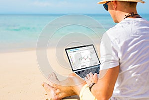 Man trading cryptocurrencies on the beach.