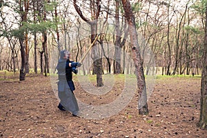 Man in a traditional armor is practicing martial arts, kendo