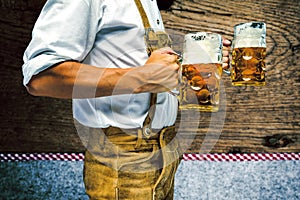 Man in traditional bavarian clothes holding mug of beer