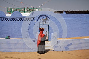 A man in traditional dress next to a traditional Nubian house, Nubia, southern Egypt, August 2015