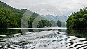 Man in traditional Thai boat going down river