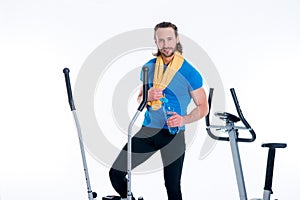 Man train with fitness machine and drinking water