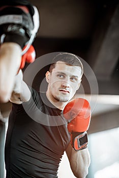 Man training with boxing coach on the boxing ring