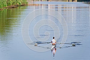 Man training on canoe to practise rowing during early morning on river