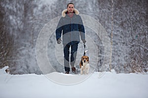 Man training dog beagle in winter. Snowing day