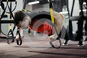 Man training with fitness straps in the gym.