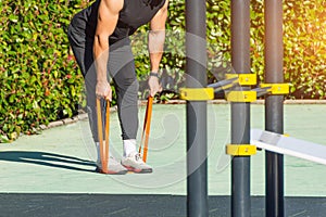 Man is training his hands and back with elastic bands. Guy exercising with rubber stepping on a rubber band. Fit, fitness,