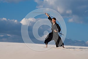 Man is training Japanese martial arts in desert