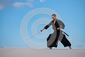 Man is training Japanese martial arts in desert