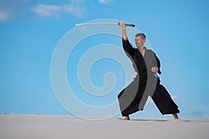 Man is training Japanese martial arts in desert