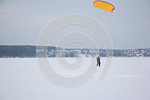 Man training with a kite on a frozen river in winter, Kama Reservoir, Perm city, Russia