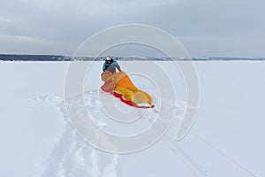 Man training with a kite on a frozen river in winter, Kama Reservoir, Perm city, Russia