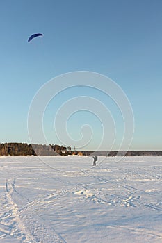 Man training with a kite on a frozen river in the winter, Ob reservoir, Novosibirsk, Russia