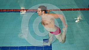The man training the leg muscles in the pool