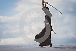 Man training martial arts in desert