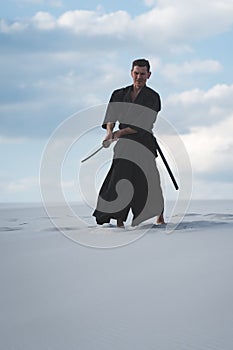 Man training martial arts in desert