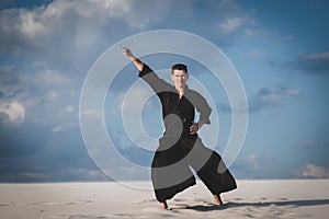 Man training martial arts in desert