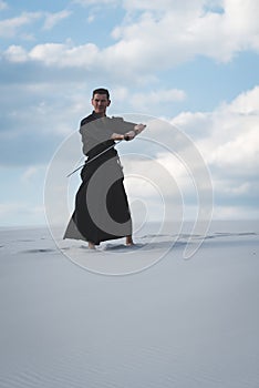 Man training martial arts in desert