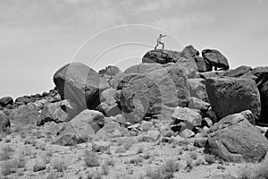 Man training on martial arts on a pile of rocks in the desert #2 -B&W-