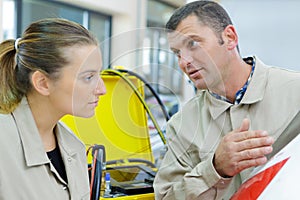 man training new apprentice in industrial workplace