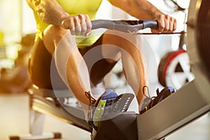 Man training on row machine in gym