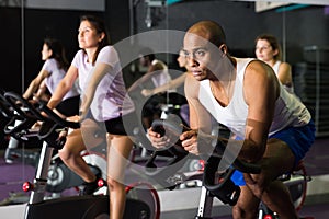 Man training on stationary bike in gym