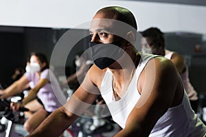 Man training on stationary bike in gym