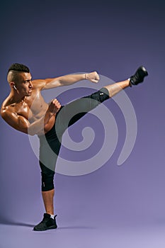 Man training taekwondo, kickboxing at sport center Isolated on blue background