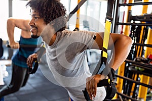 Man training with trx fitness straps in the gym. Workout healthy lifestyle sport concept