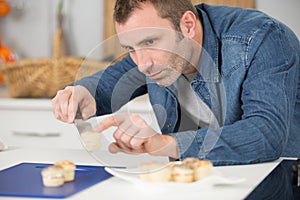 Man transferring canapes on to plate