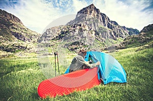 Man Traveler with camping equipment mattress and tent outdoor