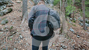 man traveler climbs rocks hiking wild northern forests trekking