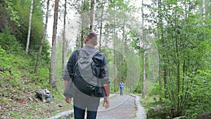 man traveler climbs rocks hiking wild northern forests trekking