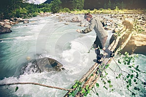 Man Traveler crossing over river on woods outdoor