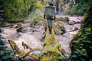 Man Traveler crossing river on log outdoor