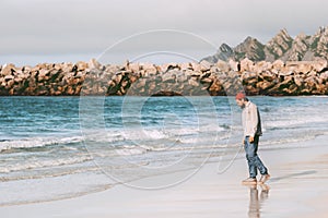 Man traveler enjoying ocean view on empty beach