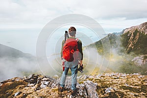 Man traveler hiking with backpack and photo camera in mountains