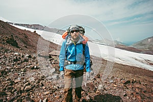 Man traveler hiking in mountains with backpack