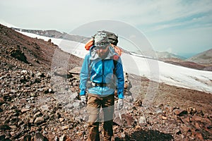 Man traveler hiking in mountains with backpack